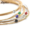 A close-up of Orphée acoustic guitar strings in bronze and silver, showing various gauges and ball ends.