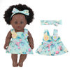 A realistic African American baby doll wearing a light blue dress with star and floral accents.