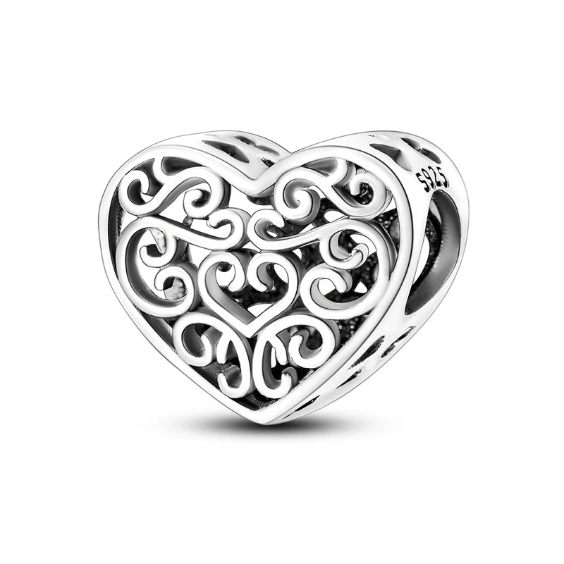 A sterling silver heart-shaped charm bead with intricate scrollwork design.