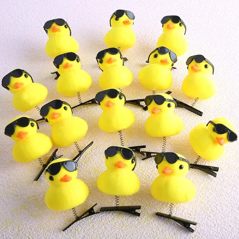 A collection of yellow 3D duck plush hair clips arranged on a white background.