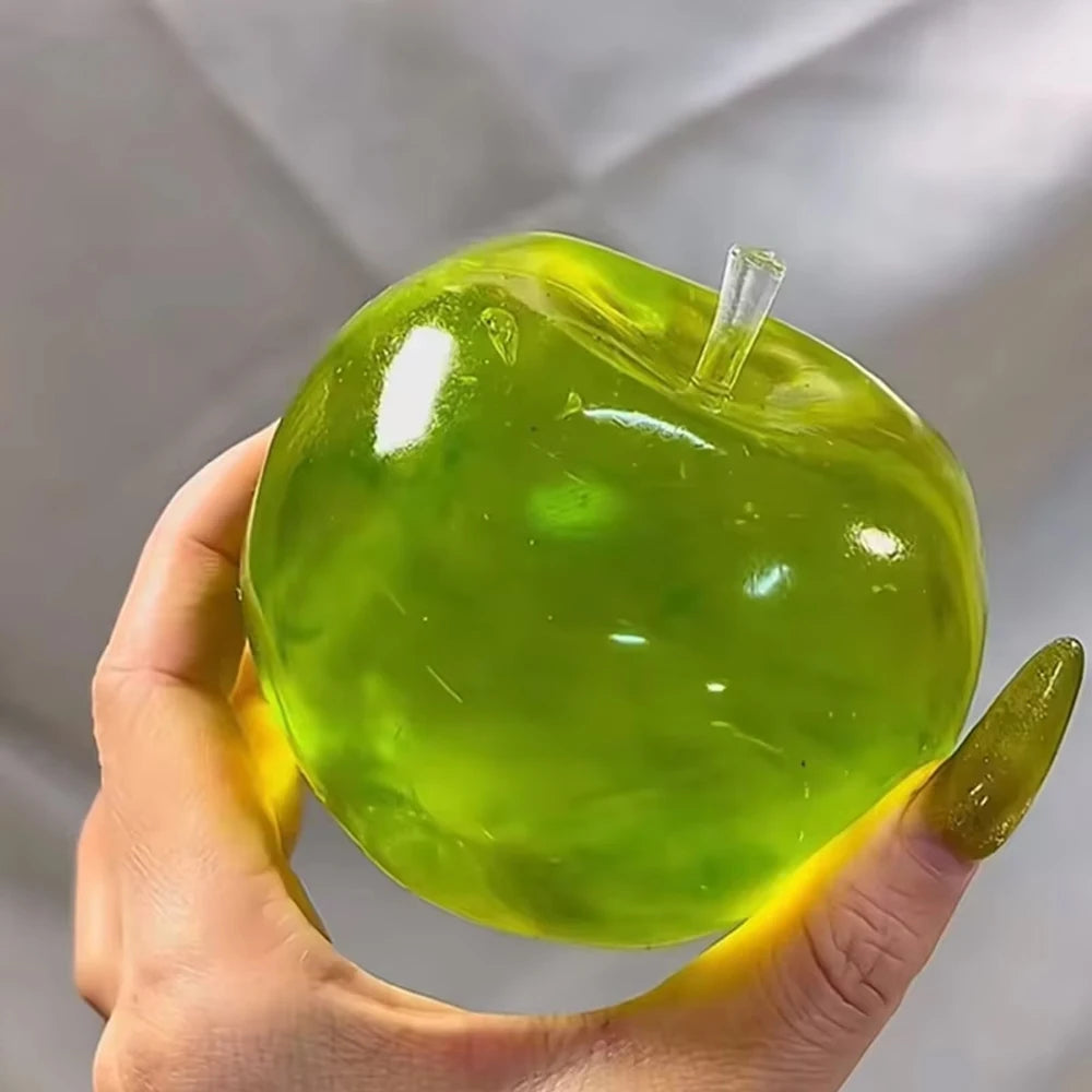 A hand holds a bright green soft maltose squishy stress relief toy with a clear plastic cap.
