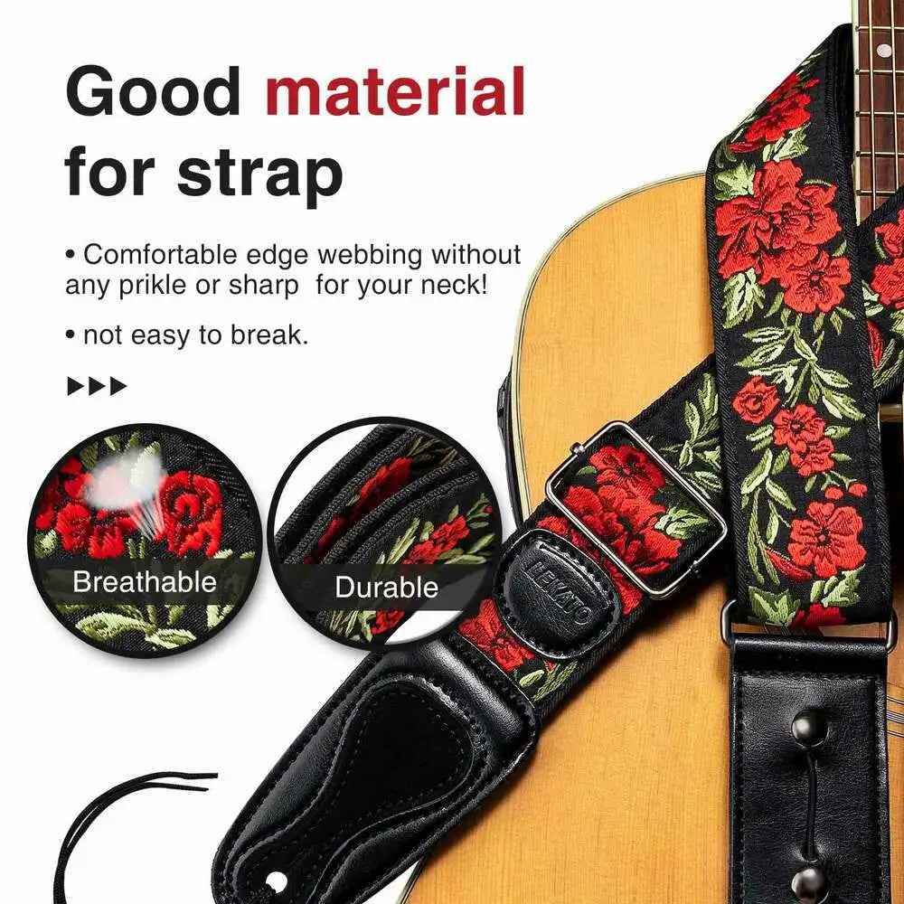A close-up of a vintage floral guitar strap featuring picks and locks on a black leather strap.