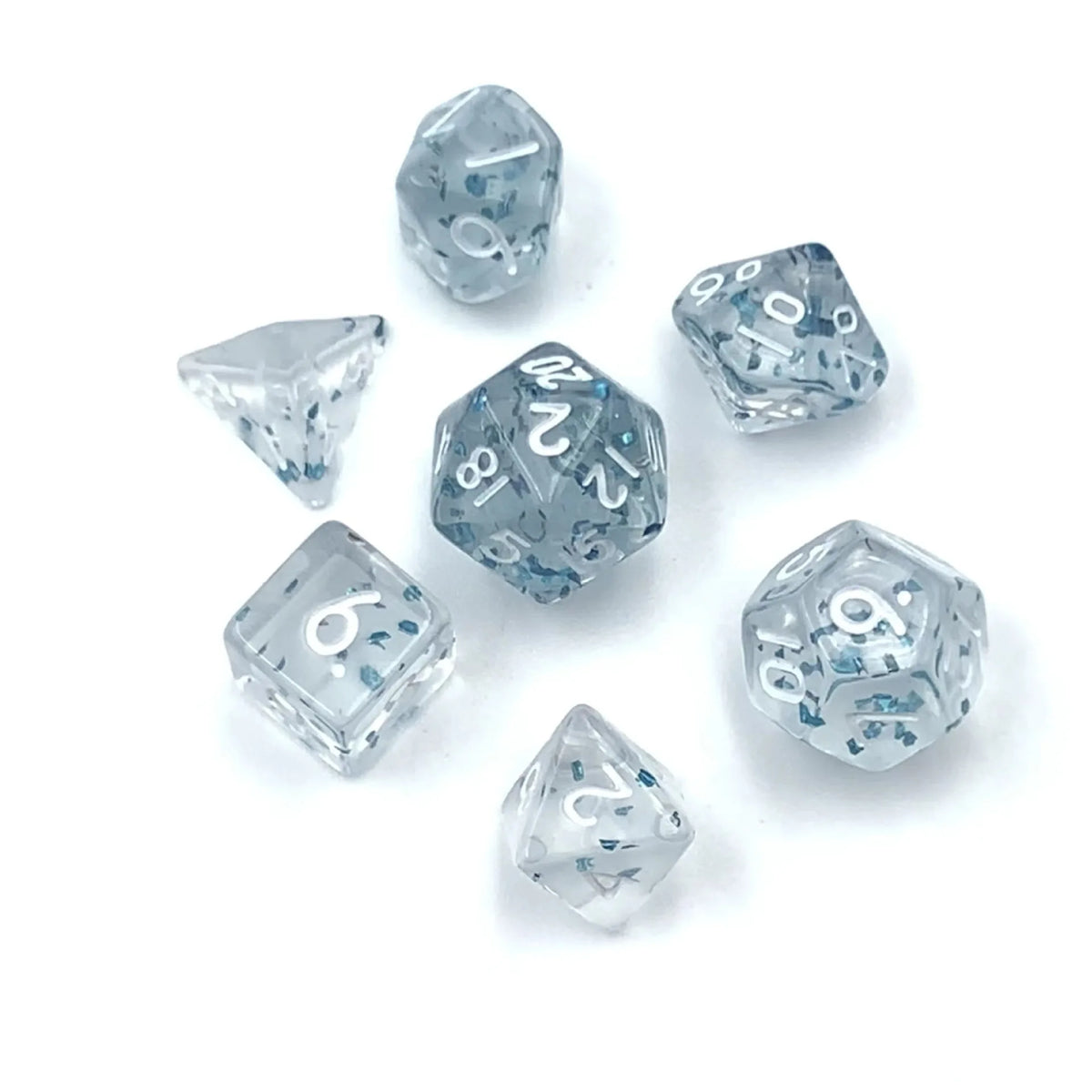 A collection of seven transparent acrylic D6 dice showing various numbers and angles on a white surface.