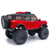 Un camion RC crawler rouge avec des pneus noirs et un porte-toit.