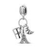 Sterling silver charm beads featuring a Eiffel Tower design and a gold-colored horn charm.