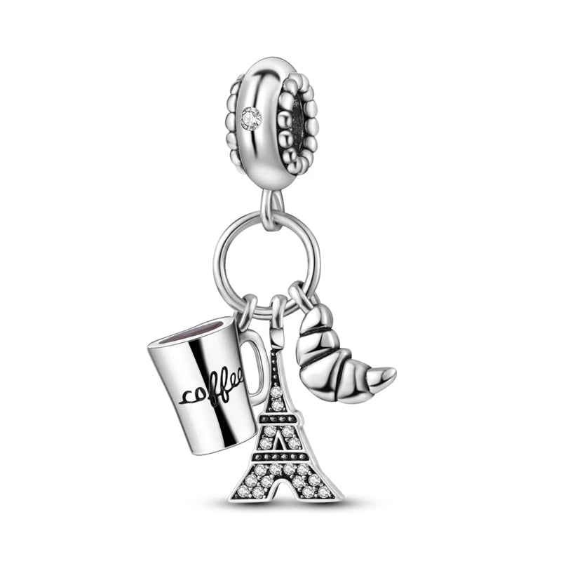 Sterling silver charm beads featuring a Eiffel Tower design and a gold-colored horn charm.