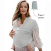 A woman is wearing a light gray knitted fabric multi-functional baby carrier with a travel pouch attached.