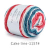 Spool of Fairyland long distance cake yarn featuring a gradient mix of red, white, and blue fibers.