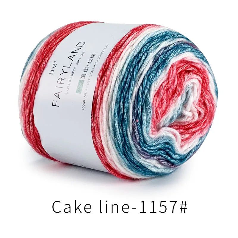 Spool of Fairyland long distance cake yarn featuring a gradient mix of red, white, and blue fibers.