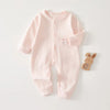 A light pink ribbed cotton baby romper for newborns and infants with a small bunny applique.