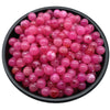 A pile of small, translucent pink and reddish round acrylic beads for jewelry making.