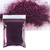 A purple holographic glitter powder in a sealed bag is shown next to a loose pile of the same glitter.