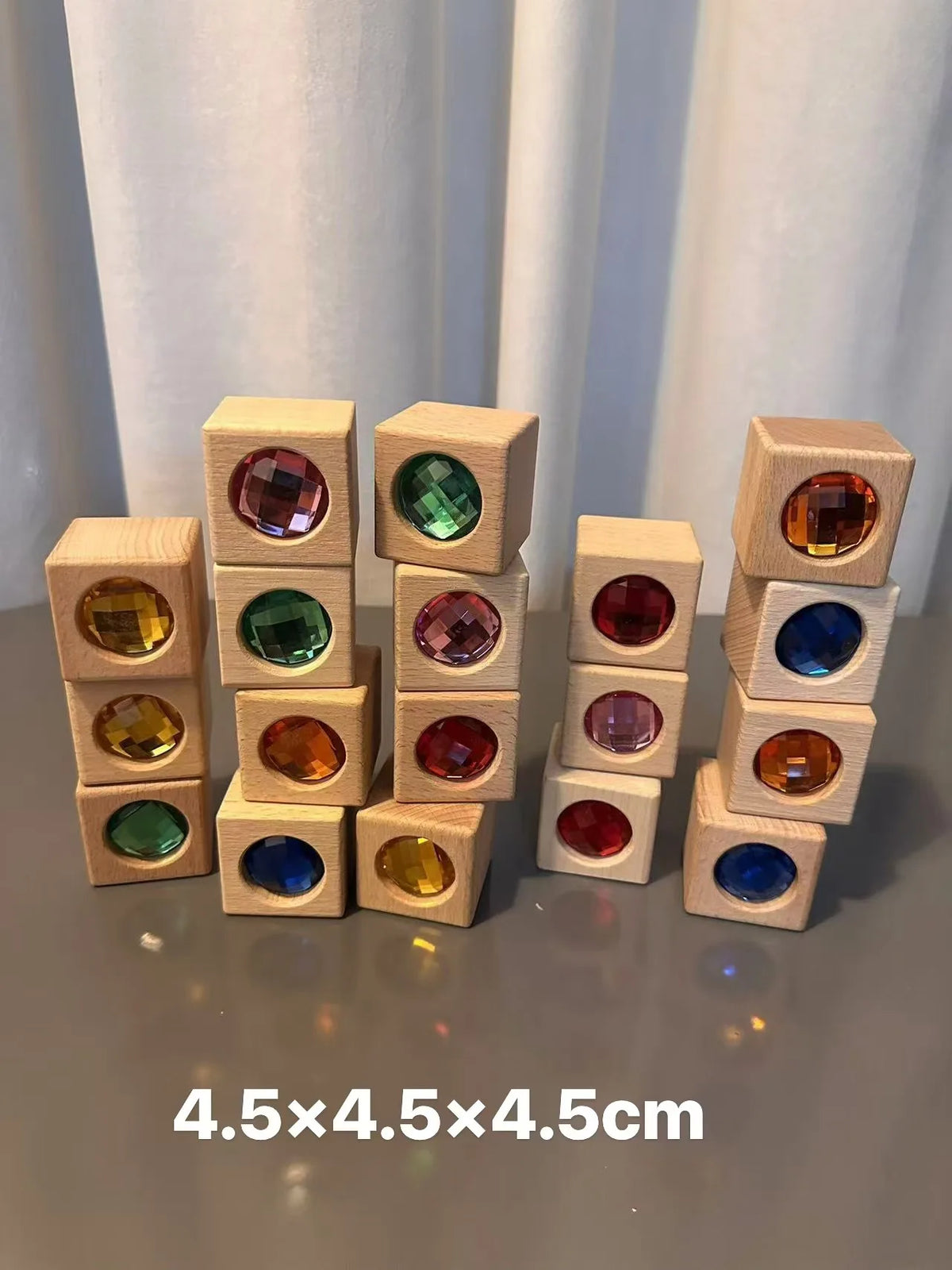 A collection of wooden building blocks with various colored acrylic gemstones arranged in a row.