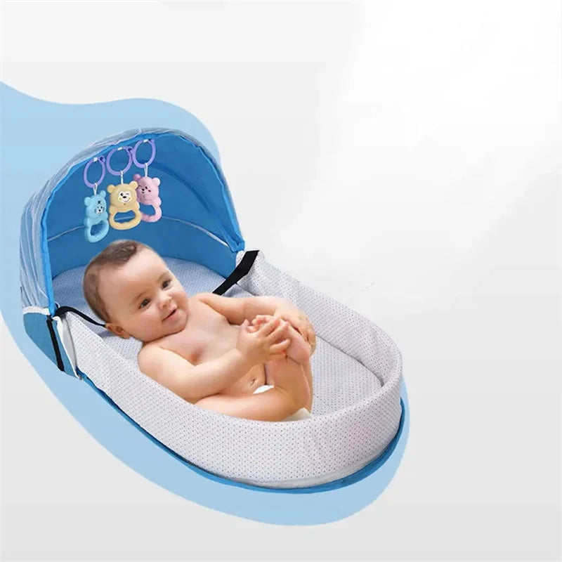 A baby is lying in a portable foldable baby bed with a mosquito net and mattress.