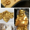 A collection of gold and silver glitter paint products including a decorative relief, a Buddha statue, and white display boxe