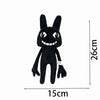 A black plush toy of a rabbit with large ears and a smiling mouth.