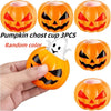 Three orange pumpkin-shaped Halloween stress balls with carved faces and a white skeleton toy shown in hand.