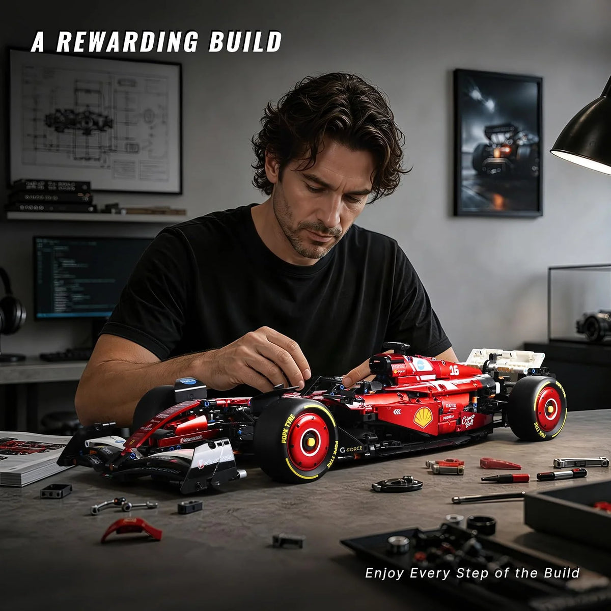 A man is assembling a detailed red 1:8 scale open-wheel racing car model kit on a dark table.
