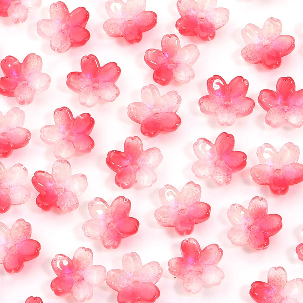 A close-up of a 50-piece set of pink cherry blossom flower glass beads for jewelry making