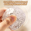 A hand is squeezing a clear, bubbly stress relief ball to produce a crunchy ASMR sound.