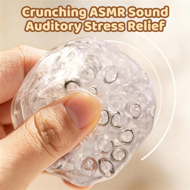 A hand is squeezing a clear, bubbly stress relief ball to produce a crunchy ASMR sound.