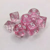 A set of ten pink acrylic polyhedral dice, including d8s and d10s, scattered on a white surface.