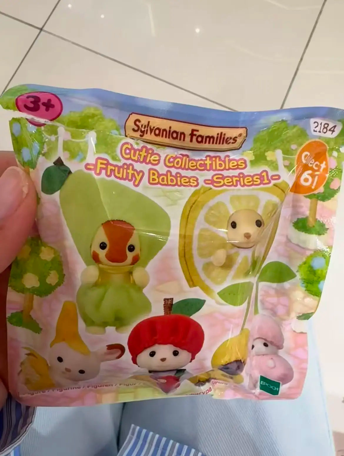 A plastic bag containing a Sylvanian Families Cutie Collectibles Fruity Babies series figure.