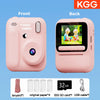 Front and back views of a pink instant print camera with accessories like paper, SD card, and USB cable.