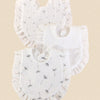 A stack of three white pure cotton muslin baby bibs with ruffled edges and embroidered stars or foliage.