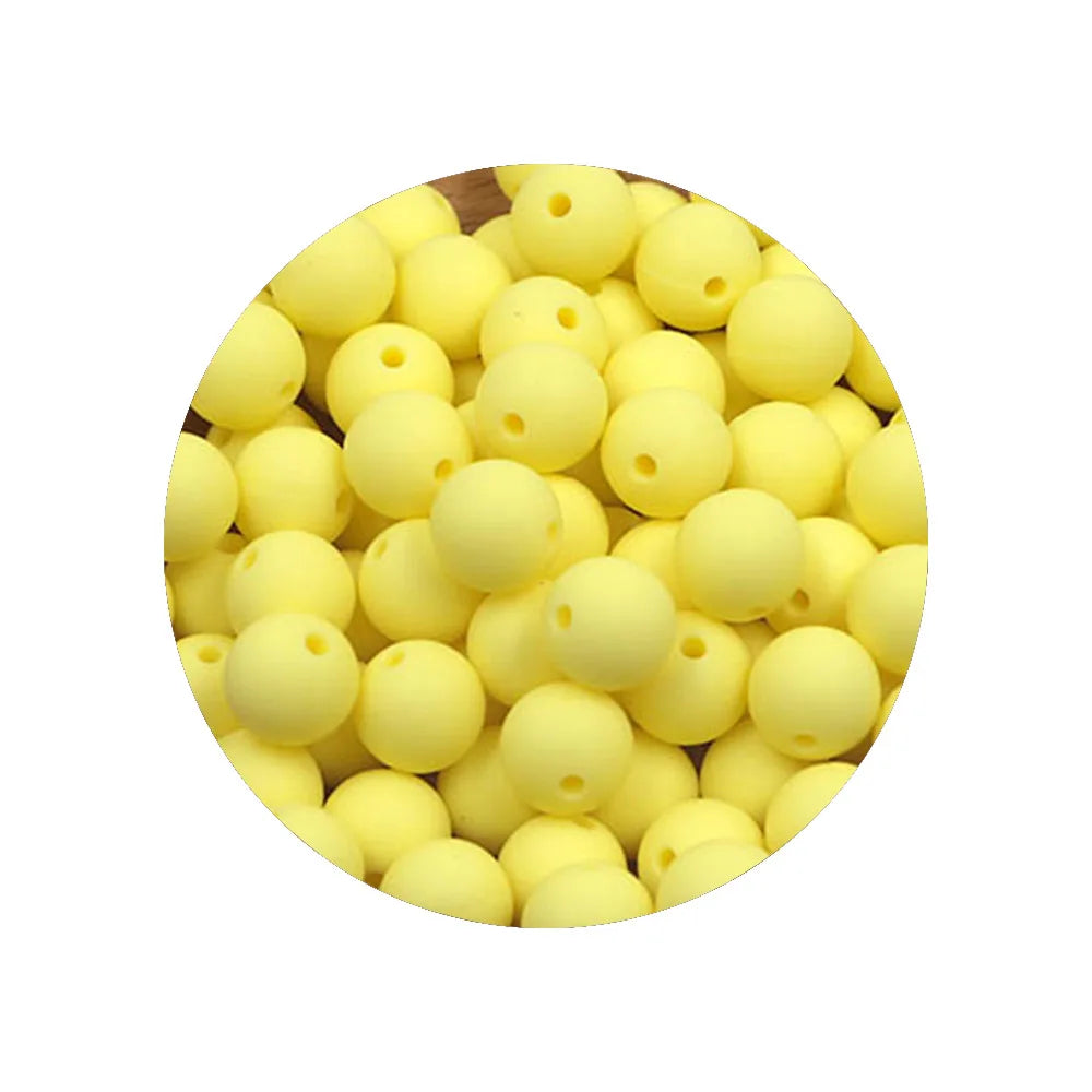 A pile of yellow silicone beads for DIY jewelry making, assorted sizes.