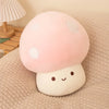 A pink and white mushroom plush pillow with round spots rests on a beige textured fabric.