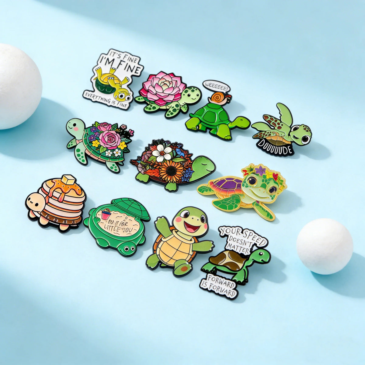 A set of cute green turtle enamel pins featuring various designs and sayings on a light blue background.