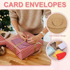 A person is preparing mini kraft paper envelopes with heart clasps for gift cards on a wooden surface.