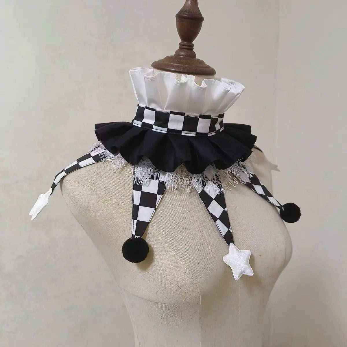 Black and white checkered ruff collar with black fabric and white lace trim displayed on a mannequin.