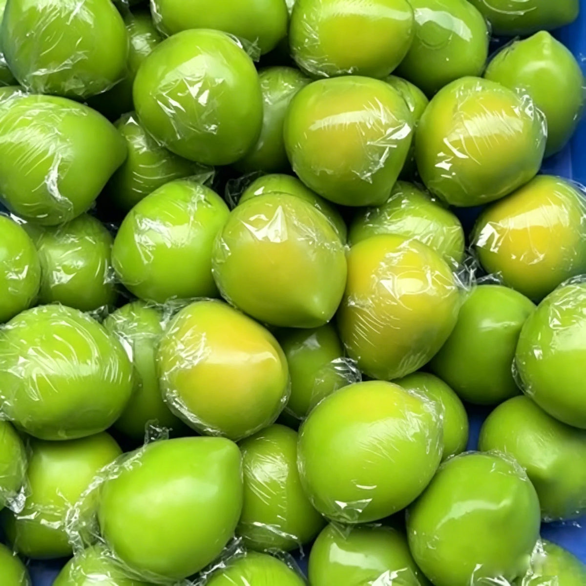 A collection of bright green and yellow handmade mango stress balls with a squishy texture.