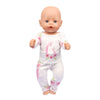 A baby doll wearing a white unicorn pajama set with pink floral accents.