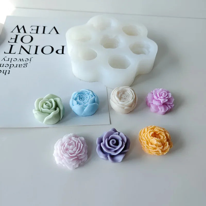 A set of white silicone molds shaped like flowers and other decorative objects for crafting.