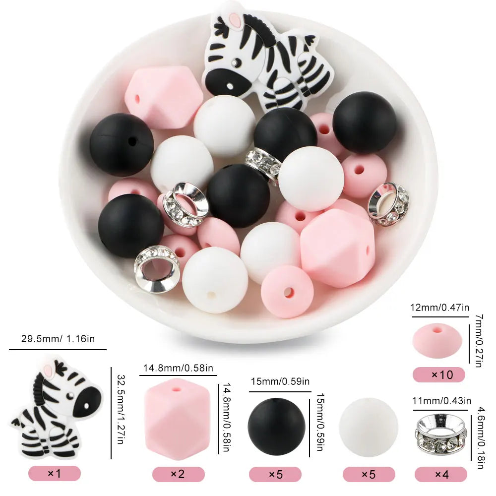 A white bowl filled with black and pink cartoon animal silicone beads, including tiger and zebra shapes.