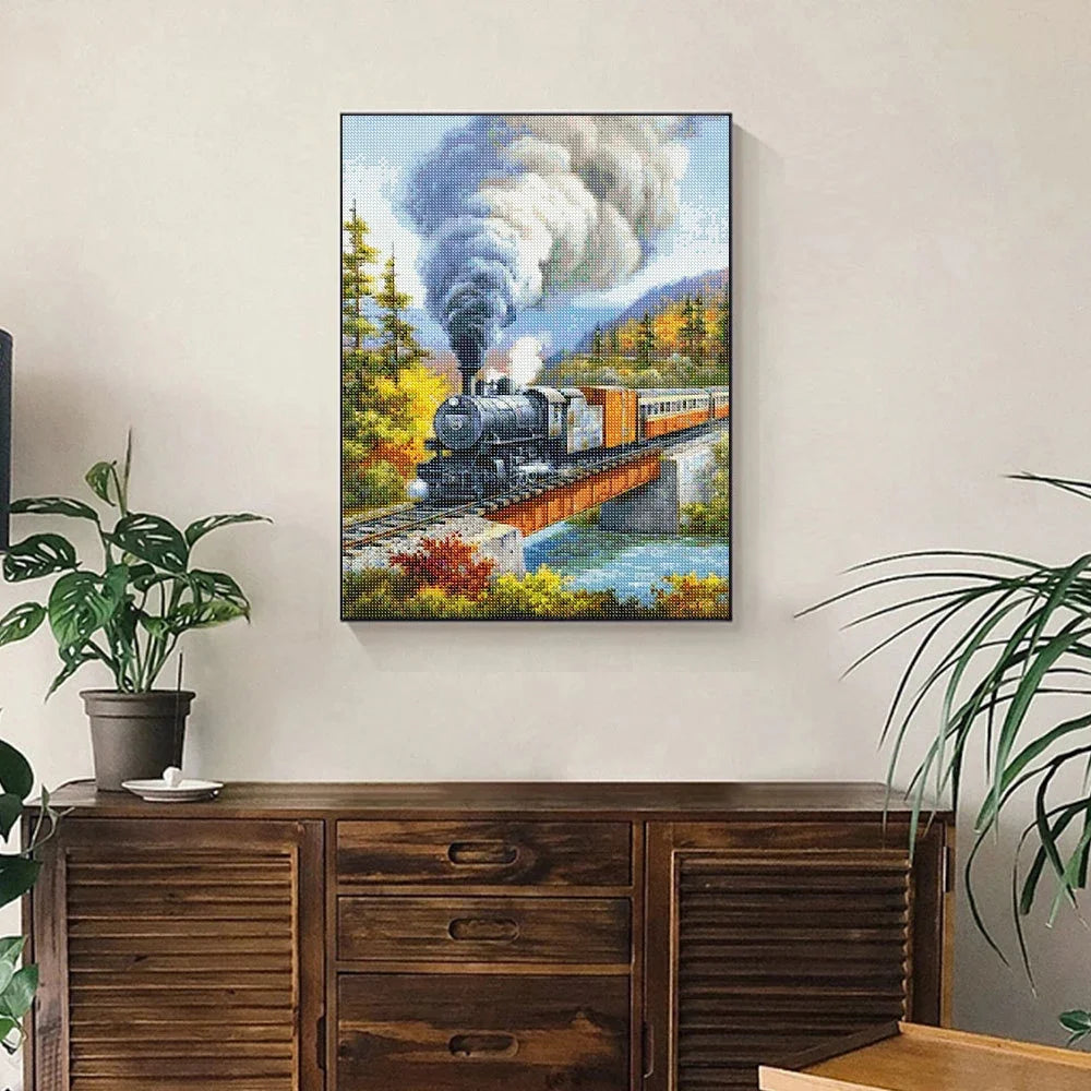 Diamond painting of a steam train crossing a bridge through a lush forest landscape