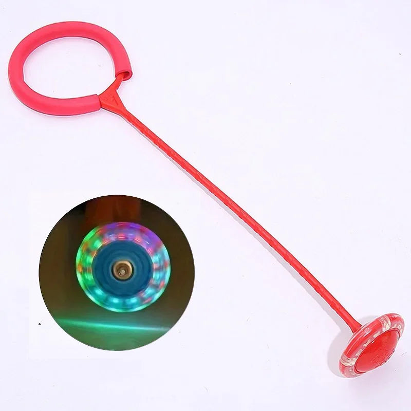 A red glowing skip ball with a loop handle used for active play and balance training.