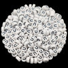 A pile of small white acrylic alphabet letter beads for jewelry making