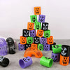 A stack of Halloween pumpkin coil spring toys in various colors including orange, green, purple, and black.