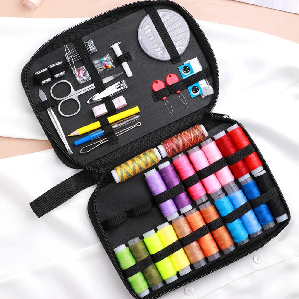 A black travel storage box containing a complete sewing kit with various tools and threads.
