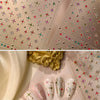 A close-up of sparkling 5D diamond nail art stickers on pink and gold paper, featuring various glitter and floral designs.