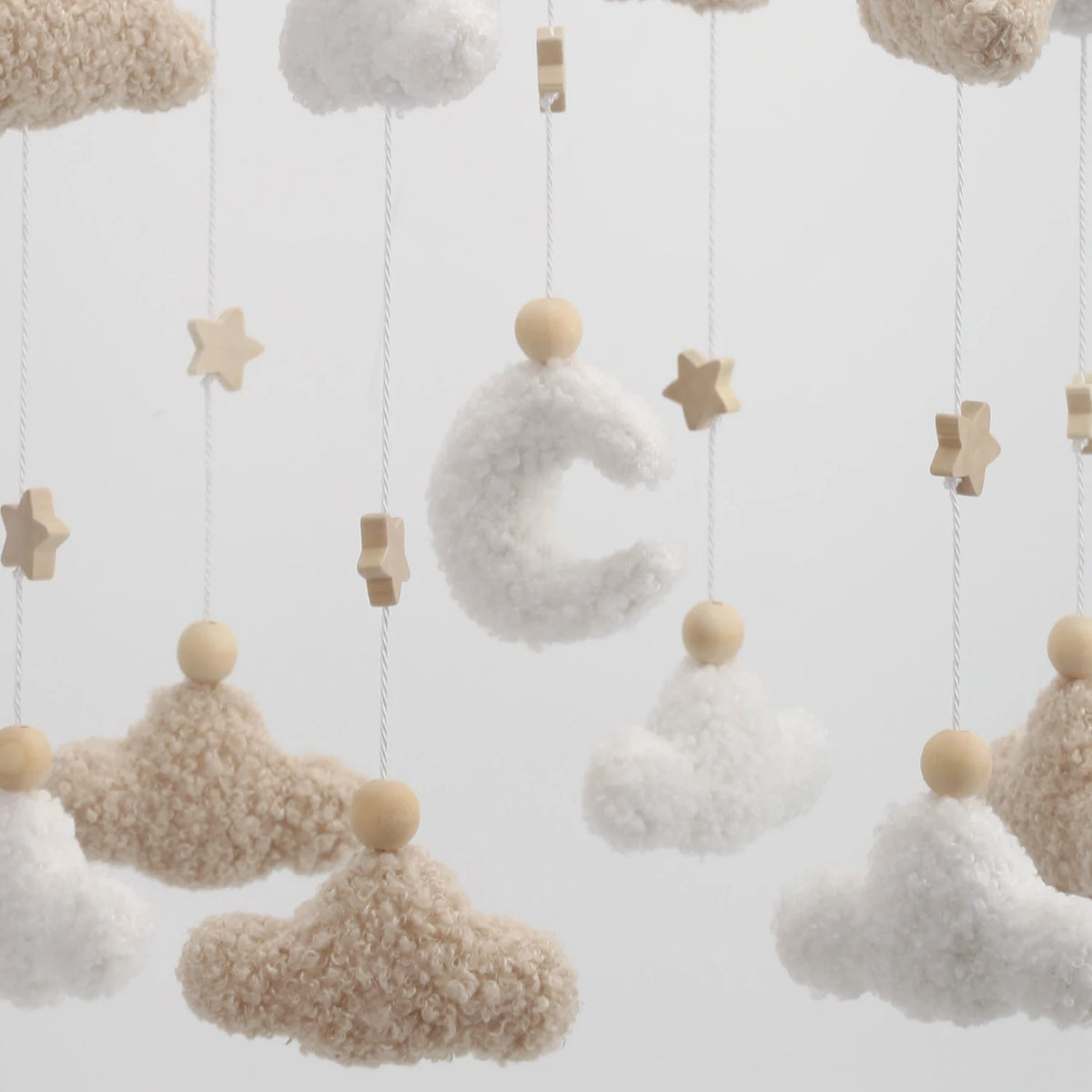 Handmade felt baby mobile featuring a crescent moon and fluffy clouds hanging from strings.