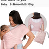 A woman is wearing a pink X-shaped baby sling carrier while holding a baby.