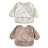 A pair of white and beige waterproof full sleeve baby bibs with a subtle animal print pattern.