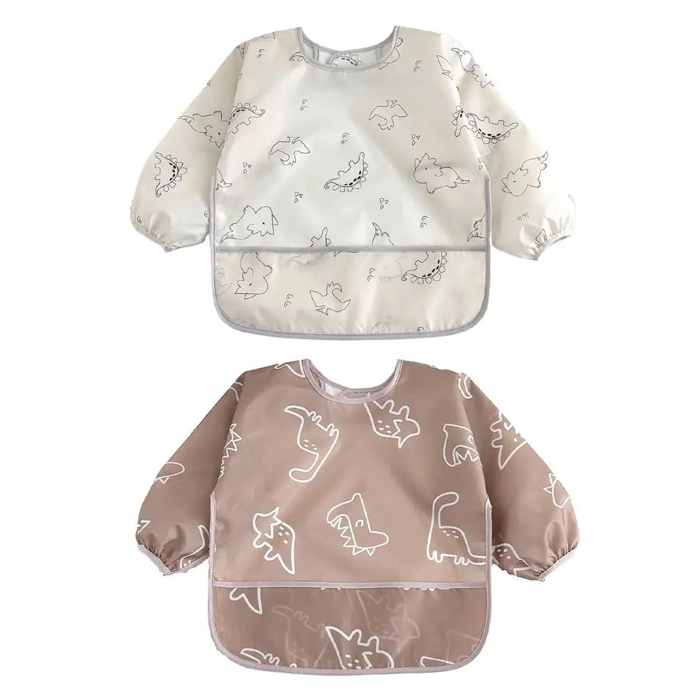 A pair of white and beige waterproof full sleeve baby bibs with a subtle animal print pattern.