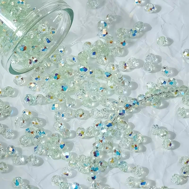 A pile of multicolor aurora cut glass beads scattered on a white surface.