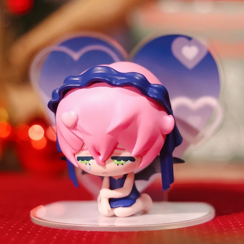 A pink and blue mini figure collectible with large eyes is displayed against a blurred background featuring heart shapes.